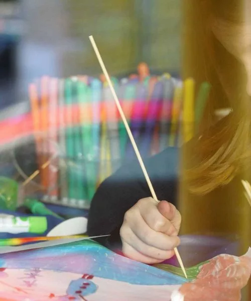 bambina colora un disegno al baby club